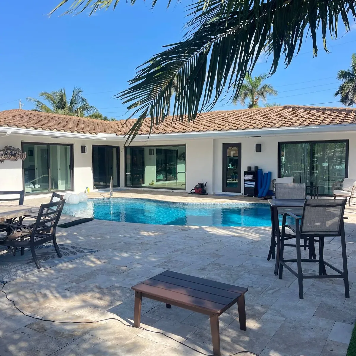 Pool patio with new dark-framed impact sliding doors and windows